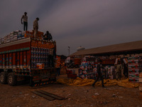 Workers load apple boxes onto trucks, which are sent to different parts of the country from Asia's largest fruit market in Sopore, Jammu and...