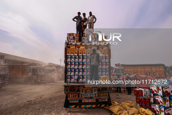 Workers load apple boxes onto trucks, which are sent to different parts of the country from Asia's largest fruit market in Sopore, Jammu and...