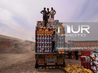 Workers load apple boxes onto trucks, which are sent to different parts of the country from Asia's largest fruit market in Sopore, Jammu and...