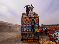 Workers load apple boxes onto trucks, which are sent to different parts of the country from Asia's largest fruit market in Sopore, Jammu and...