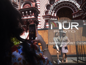 Tourists take pictures in front of the Red Mosque in Colombo, Sri Lanka, on October 26, 2024.   (