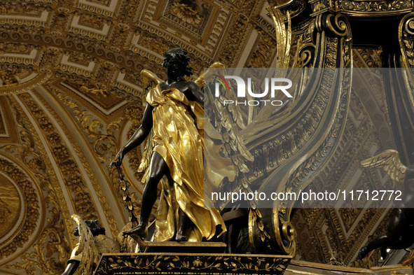 A picture shows a statue of the newly renovated baldachin, a large Baroque sculpted bronze canopy over the high altar of St. Peter's Basilic...