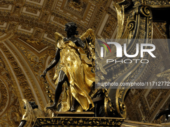 A picture shows a statue of the newly renovated baldachin, a large Baroque sculpted bronze canopy over the high altar of St. Peter's Basilic...