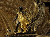 A picture shows a statue of the newly renovated baldachin, a large Baroque sculpted bronze canopy over the high altar of St. Peter's Basilic...