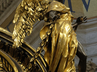 A picture shows a statue of the newly renovated baldachin, a large Baroque sculpted bronze canopy over the high altar of St. Peter's Basilic...