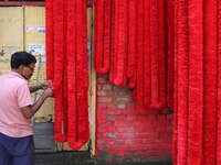 A vendor prepares the garlands kept on sale to decorate the idol of the Hindu goddess Kali at a workshop area in Kolkata, India, on October...