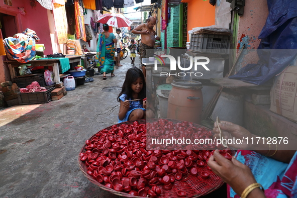 A girl colors earthen lamps, which are used to decorate temples and homes during the Hindu festival of Diwali, in Kolkata, India, on October...