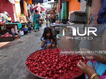 A girl colors earthen lamps, which are used to decorate temples and homes during the Hindu festival of Diwali, in Kolkata, India, on October...