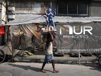 A man carries an idol of the Hindu goddess Kali towards a workshop in Kolkata, India, on October 27, 2024. Diwali comes from the Sanskrit wo...