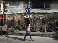 A man carries an idol of the Hindu goddess Kali towards a workshop in Kolkata, India, on October 27, 2024. Diwali comes from the Sanskrit wo...