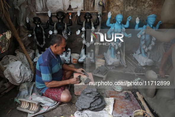 An artist works on an idol of the Hindu goddess Kali at a roadside workshop ahead of the Kali Puja festival and Diwali festival in Kolkata,...