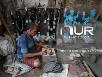 An artist works on an idol of the Hindu goddess Kali at a roadside workshop ahead of the Kali Puja festival and Diwali festival in Kolkata,...