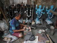 An artist works on an idol of the Hindu goddess Kali at a roadside workshop ahead of the Kali Puja festival and Diwali festival in Kolkata,...