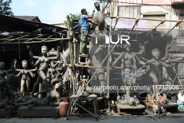 An artist works on an idol of the Hindu goddess Kali at a roadside workshop ahead of the Kali Puja festival and Diwali festival in Kolkata,...