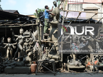 An artist works on an idol of the Hindu goddess Kali at a roadside workshop ahead of the Kali Puja festival and Diwali festival in Kolkata,...