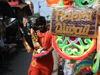 A man carries an idol of the Hindu goddess Kali for worship and walks towards his house in a workshop area ahead of the Diwali festival in K...