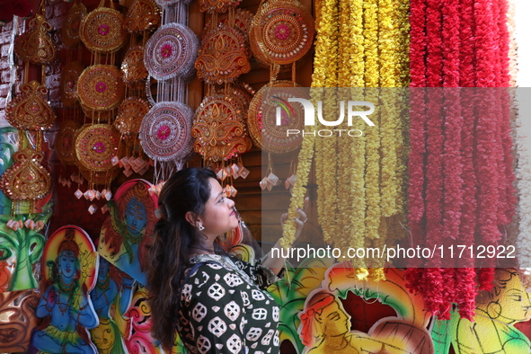 A looks at a garland kept on sale to decorate the idol of the Hindu goddess Kali at a workshop area in Kolkata, India, on October 27, 2024....