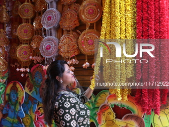 A looks at a garland kept on sale to decorate the idol of the Hindu goddess Kali at a workshop area in Kolkata, India, on October 27, 2024....