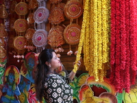 A looks at a garland kept on sale to decorate the idol of the Hindu goddess Kali at a workshop area in Kolkata, India, on October 27, 2024....