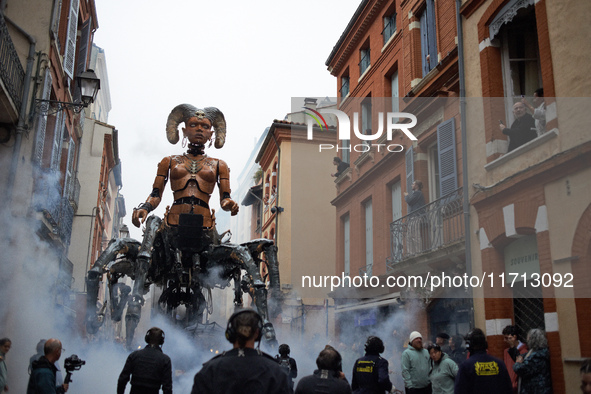 Lilith, the giant scorpion woman, is guided on one of the tiniest streets of Toulouse. French street show creator Francois Delaroziere, dire...