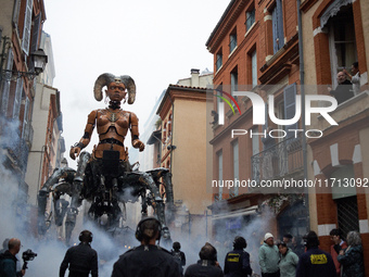 Lilith, the giant scorpion woman, is guided on one of the tiniest streets of Toulouse. French street show creator Francois Delaroziere, dire...