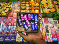 A person displays firecrackers for sale inside a firecracker market ahead of the Diwali festival in Kolkata, India, on October 27, 2024. (