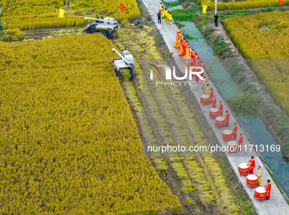 Villagers beat gongs, drums, and wave golden dragons in the fields to celebrate another harvest season in Qihu village, Huai'an city, Jiangs...