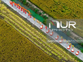 Villagers beat gongs, drums, and wave golden dragons in the fields to celebrate another harvest season in Qihu village, Huai'an city, Jiangs...