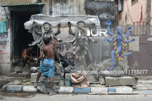 An idol maker creates an idol of the Hindu goddess Kali ahead of the Kali Puja festival in Kolkata, India, on October 27, 2024. 