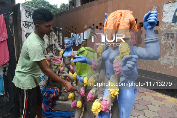 An idol maker paints an idol of the Hindu goddess Kali ahead of the Kali Puja festival in Kolkata, India, on October 27, 2024. 