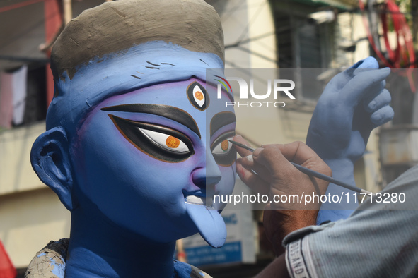 An idol maker paints an idol of the Hindu goddess Kali ahead of the Kali Puja festival in Kolkata, India, on October 27, 2024. 