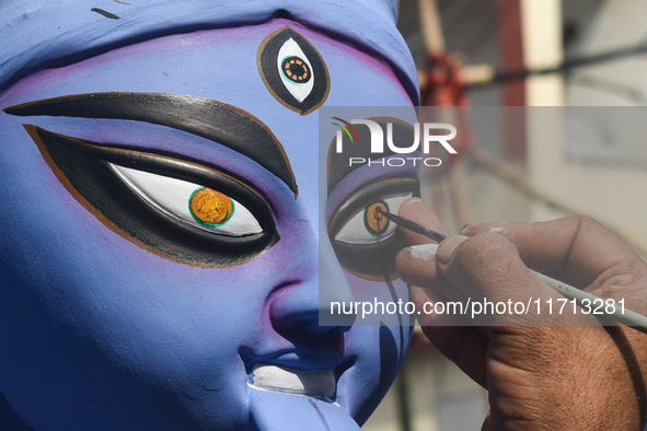 An idol maker draws the eye of an idol of the Hindu goddess Kali ahead of the Kali Puja festival in Kolkata, India, on October 27, 2024. 