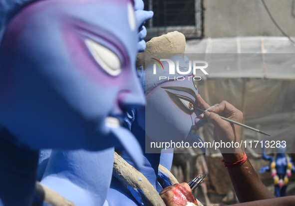 An idol maker draws the eye of an idol of the Hindu goddess Kali ahead of the Kali Puja festival in Kolkata, India, on October 27, 2024. 