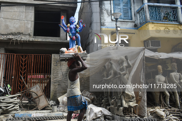 A porter carries an idol of the Hindu goddess Kali on his head ahead of the Kali Puja festival in Kolkata, India, on October 27, 2024. 