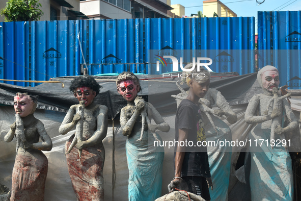 A boy walks past semi-finished clay idols of the Hindu mythological characters 'Dakinis' and 'Yoginis', who are worshipped along with the Hi...