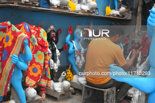 An idol maker paints an idol of the Hindu goddess Kali ahead of the Kali Puja festival in Kolkata, India, on October 27, 2024. 