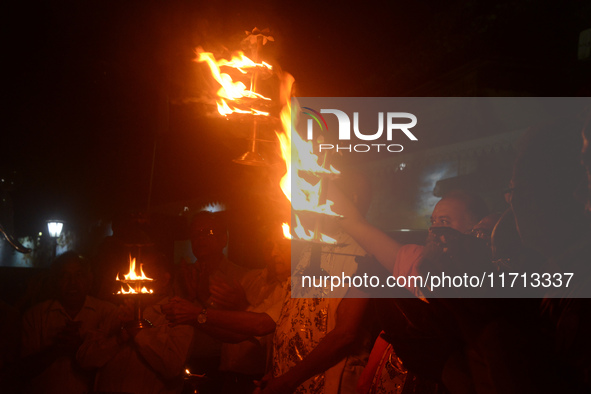 Priests, along with residents of Siliguri, illuminate earthen lamps on the riverbank of the Mahananda in Siliguri, India, on October 27, 202...