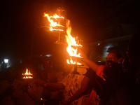 Priests, along with residents of Siliguri, illuminate earthen lamps on the riverbank of the Mahananda in Siliguri, India, on October 27, 202...