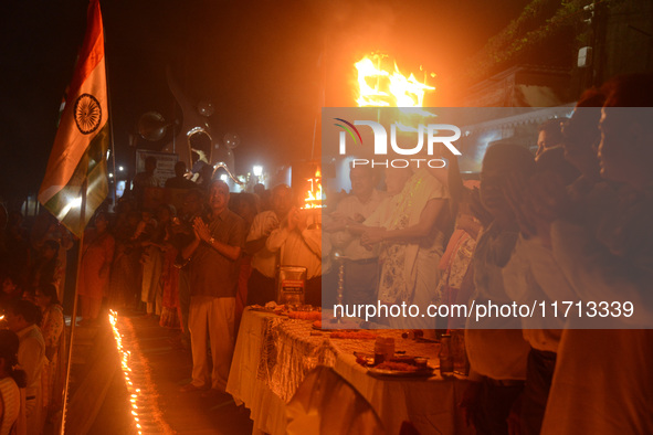 Priests, along with residents of Siliguri, illuminate earthen lamps on the riverbank of the Mahananda in Siliguri, India, on October 27, 202...