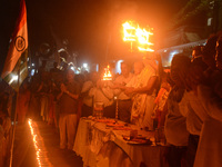 Priests, along with residents of Siliguri, illuminate earthen lamps on the riverbank of the Mahananda in Siliguri, India, on October 27, 202...