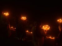 Priests, along with residents of Siliguri, illuminate earthen lamps on the riverbank of the Mahananda in Siliguri, India, on October 27, 202...