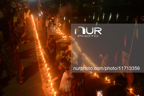 Priests, along with residents of Siliguri, illuminate earthen lamps on the riverbank of the Mahananda in Siliguri, India, on October 27, 202...