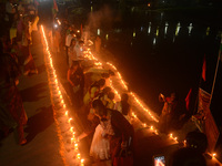 Priests, along with residents of Siliguri, illuminate earthen lamps on the riverbank of the Mahananda in Siliguri, India, on October 27, 202...