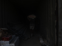 Porters load sacks of cement at the port of Belawan for the USU Residence III housing complex in Patumbak, Deli Serdang, North Sumatra, on O...