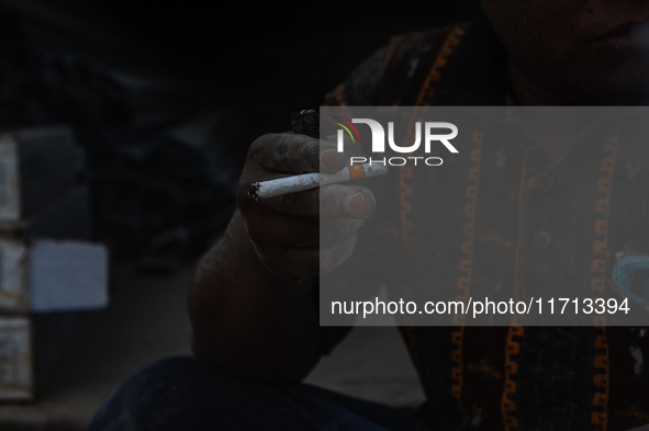 Porters rest after loading sacks of cement at the port of Belawan for the USU Residence III housing complex in Patumbak, Deli Serdang, North...