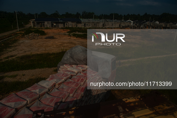 Porters load sacks of cement at the port of Belawan for the USU Residence III housing complex in Patumbak, Deli Serdang, North Sumatra, on O...