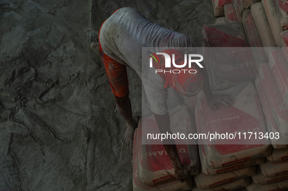 Porters load sacks of cement at the port of Belawan for the USU Residence III housing complex in Patumbak, Deli Serdang, North Sumatra, on O...