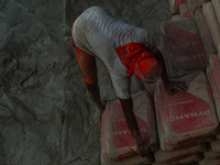 Porters load sacks of cement at the port of Belawan for the USU Residence III housing complex in Patumbak, Deli Serdang, North Sumatra, on O...