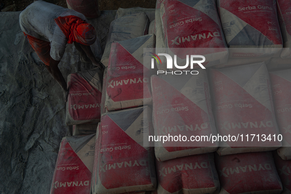 Porters load sacks of cement at the port of Belawan for the USU Residence III housing complex in Patumbak, Deli Serdang, North Sumatra, on O...