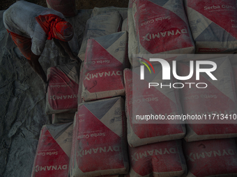 Porters load sacks of cement at the port of Belawan for the USU Residence III housing complex in Patumbak, Deli Serdang, North Sumatra, on O...